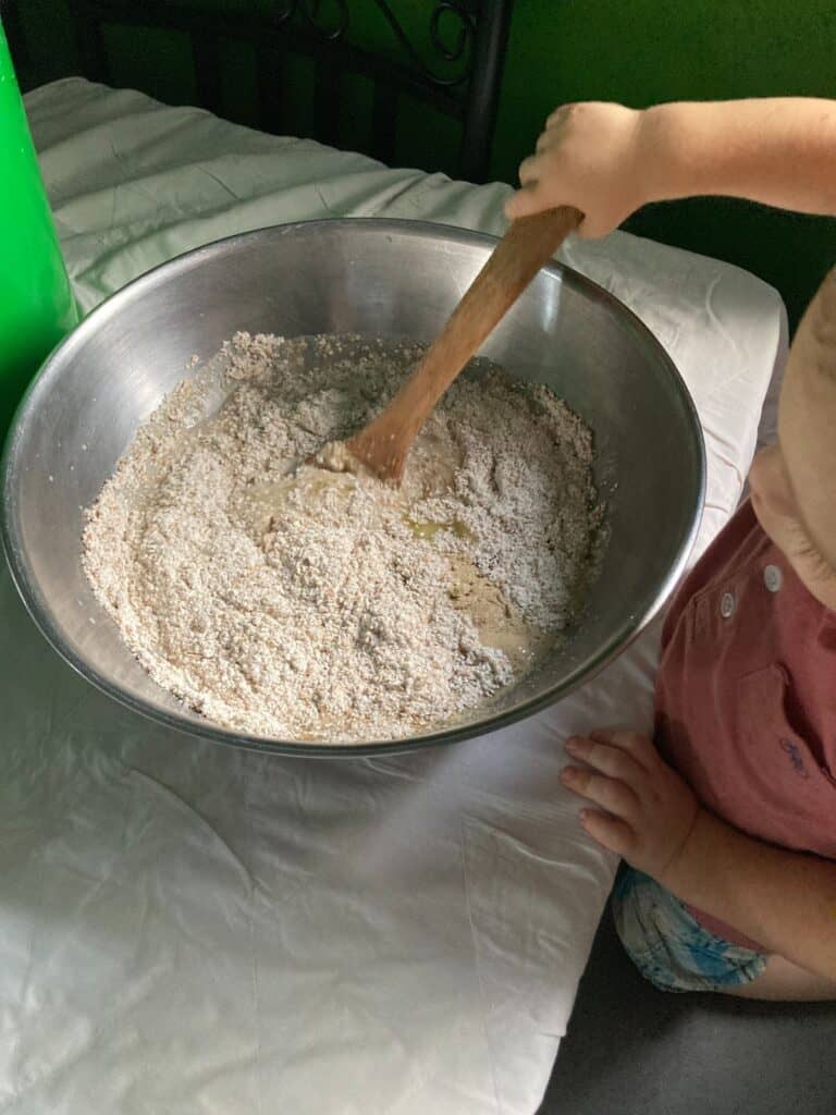 child stirring bread dough