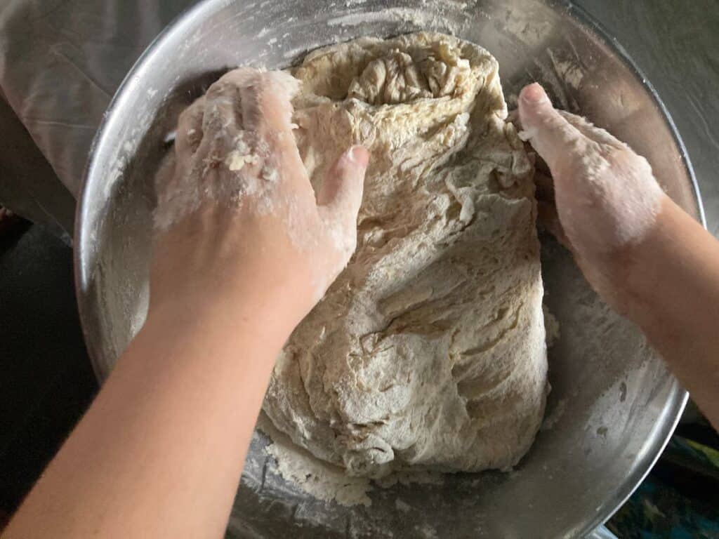 hands kneading bread dough