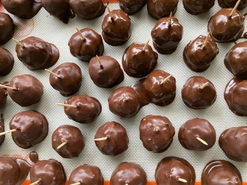 chocolate snack balls cooling with toothpicks